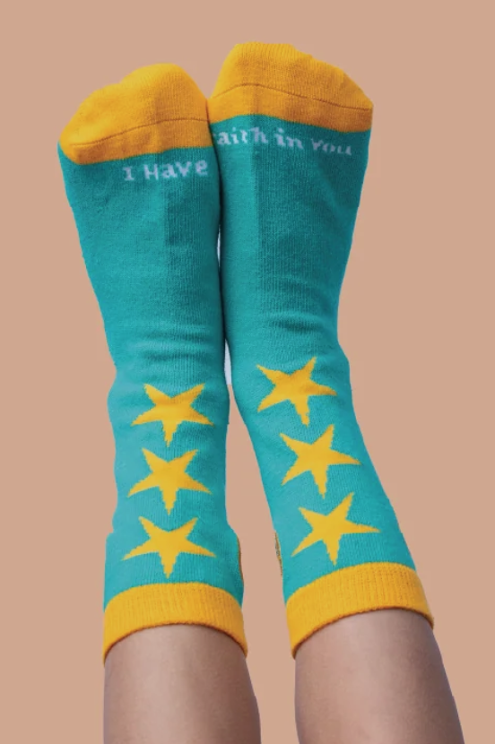 Green and yellow star socks shown as worn by a child